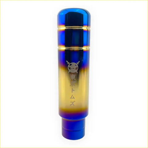 A 13cm tokyo toms kanji gear knob made of stainless steel with vibrant blue to gold gradient and engraved japanese text