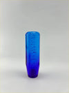 Translucent cobalt blue glass bubble gear knob with rectangular body and raised dot pattern in purple blue finish