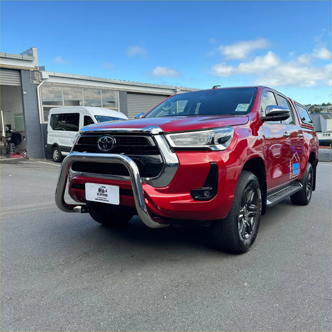 Red toyota hilux pickup truck with chrome 304 stainless steel nudge bar and black alloy wheels front view