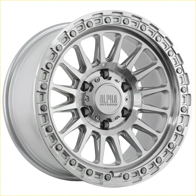 Silver alpha combat 17x9 off-road wheel with machined finish and intricate spoke design for rugged use