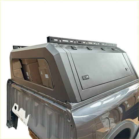 Gray metallic aluminum canopy carport cover with sleek angular design and roof rack for nissan navara double cab back view