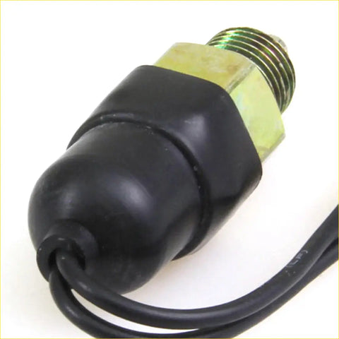 Back of black rubber-coated back switch light with brass threaded fitting and black cable for Nissan Datsun 521 and 720 ute