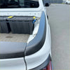 Black textured bedside rail covers 3 piece set shown on the rear side of a white 2021+ nissan navara pickup truck