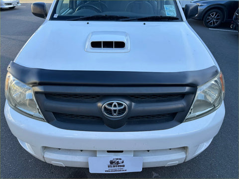 White toyota hilux pickup truck with matte black bonnet guard featuring a black grille and hood scoop