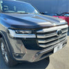 Dark gray metallic toyota land cruiser lc300 with chrome grille and sleek led headlights featuring bonnet guard protector stone guard