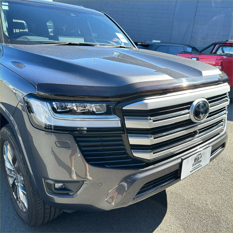 Dark gray metallic toyota land cruiser lc300 with chrome grille and sleek led headlights featuring bonnet guard protector stone guard