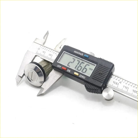 A shiny chrome door lock cylinder being measured with a digital caliper for toyota hilux 1978-1983