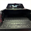 Black textured truck bed liner with molded grip patterns and drainage channels for electric roller shutter tonneau cover