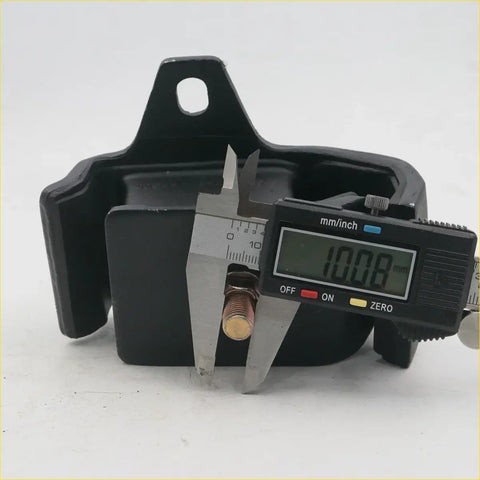 Black rubber engine mount with brass bolt being measured by digital caliper for nissan datsun pick-up d21 1985-1999