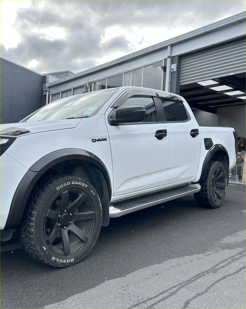 White d-max pickup truck showing rear with matte black 4-inch fender flares black wheels and side steps