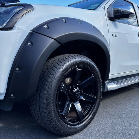Black matte finish plastic fender flare with silver bolts mounted on white isuzu d-max 2016-2020 pickup truck