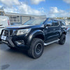 Black nissan navara np300 pickup with bolt style fender flares rugged off-road tires and protective front bumper