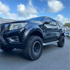 Black nissan navara np300 2015-2020 with bolt style fender flares and rugged off-road tires in a glossy finish