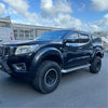 Black nissan navara np300 2015-2020 with bolt style fender flares rugged tires and protective front bumper