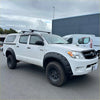 White toyota hilux pickup truck with bolt style textured black fender flares and roof rack from 2005 to 2012