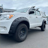 White toyota hilux pickup with black textured bolt style fender flares and rugged tires for 2005-2012 vigo models