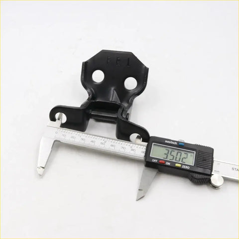Black plastic front door hinge for Toyota Hilux 1978-1983 with two circular holes and central hinge mechanism visible