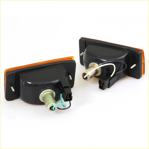 Black plastic front turn signal lightset with orange lens and wiring for nissan sentra b11 1982-1986 seen from back