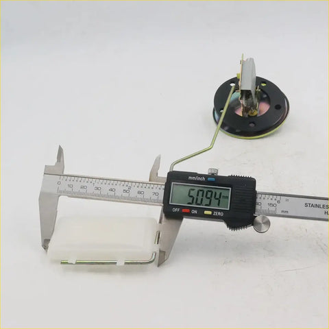 A black digital caliper with silver metallic jaws measuring millimeters shown with a fuel sender gauge for toyota hilux 1979-1983