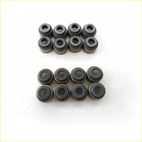 Set of 16 black valve stem oil seals for toyota hiace hilux 2trfe arranged in two rows on white surface