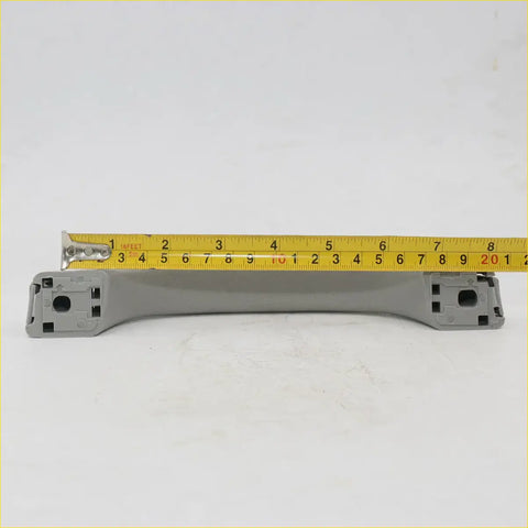 Gray plastic grab handle with molded mounting brackets for mitsubishi triton strada 2012-2016 shown from back side