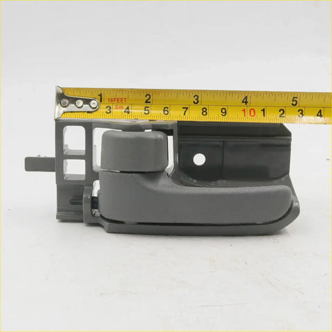 Gray plastic left door handle bezel with integrated latch for toyota hilux 2004-2015 showing back side