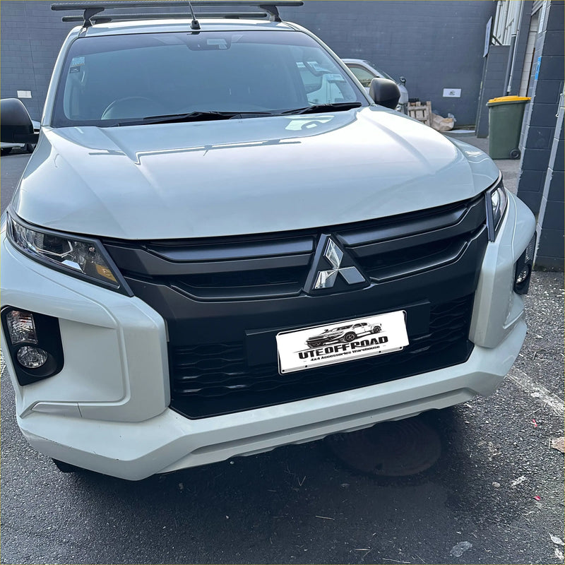 White mitsubishi triton 2019-2023 with matte black headlight covers black grille and roof rack utility vehicle