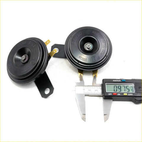 Black plastic denso horn with gold metal terminals and bracket for toyota hilux 1968-1997 shown from back side