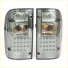 A pair of sleek smoked led tail lights with clear and amber lenses for toyota hilux mk4 mk5 1988-1997 back side view