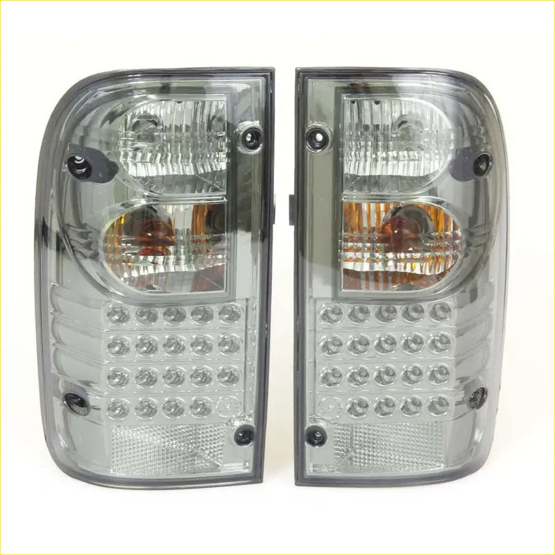 A pair of sleek smoked led tail lights with clear and amber lenses for toyota hilux mk4 mk5 1988-1997 back side view