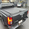 Black triton manual roller shutter truck bed cover with textured surface and integrated handle for mitsubishi triton 2024+