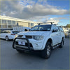 White mitsubishi triton pickup with matte black nudge bar compatible with front sensors and roof rack accessory