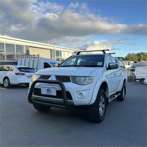 White Mitsubishi Triton pickup with matte black nudge bar compatible with front sensors and roof rack 2005-2015 model