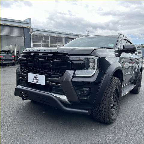 Black ford ranger wildtrak with a rugged matte finish and aggressive front grille featuring a nudge bar for 2022+ models