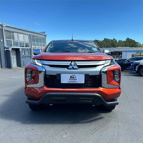 Vibrant red mitsubishi triton pickup with black q1 nudge bar featuring bold chrome grille and sleek led headlights