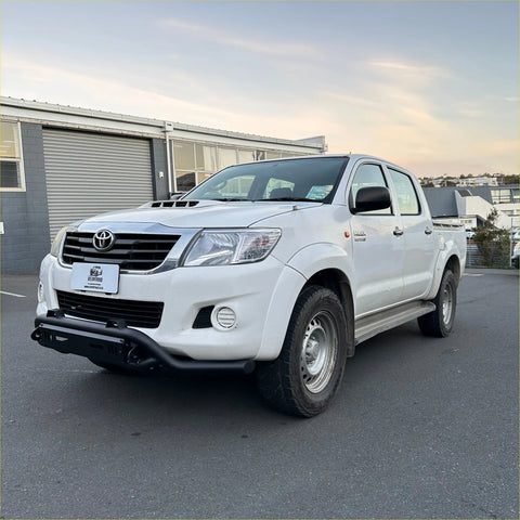 White toyota hilux vigo 2012-2015 with black nudge bar lower style, front bumper, and side steps visible