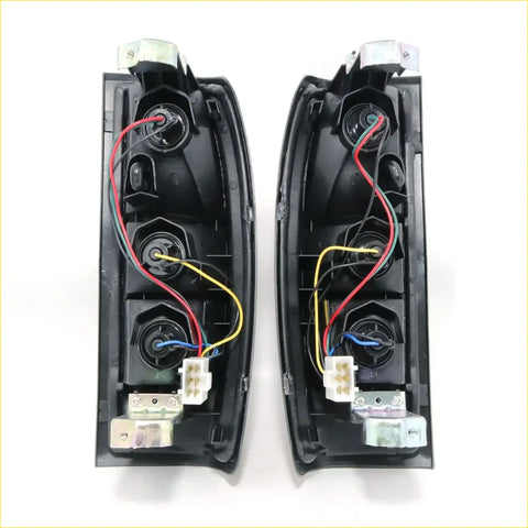 Black plastic rear tail light assemblies with wiring and connectors for Nissan Datsun Navara D22 1997-2004 back side