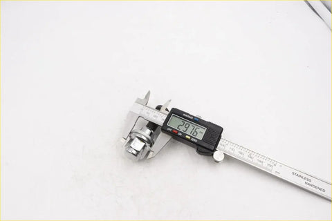 Digital caliper with black and silver body measuring 24.16 mm on stainless steel scale for rear wheel nut chrome toyota hilux
