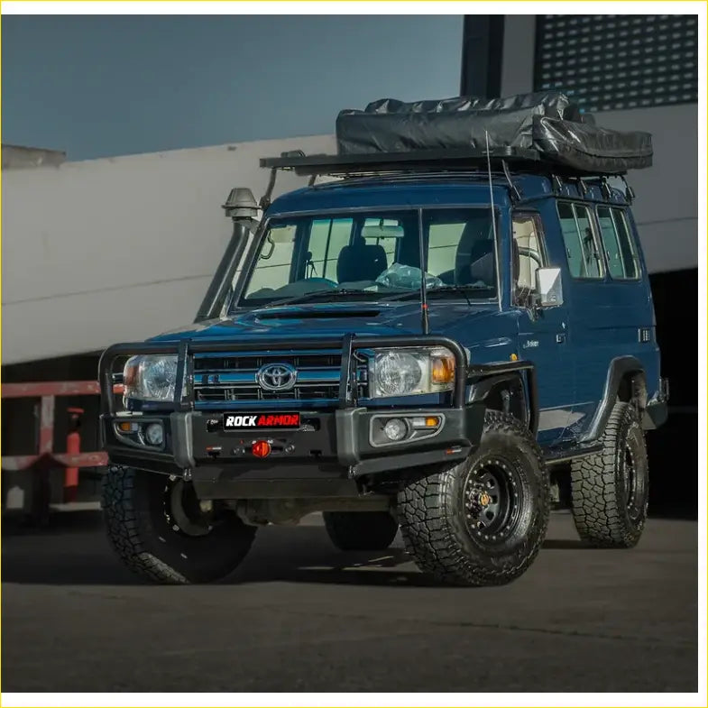 Deep blue toyota land cruiser with black rockarmor brushbar front bumper and roof rack for offroad 4wd use