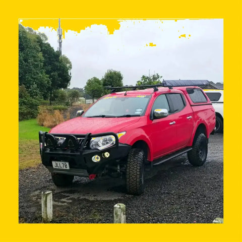 Vibrant red mitsubishi triton pickup with black steel rockarmor gt hoop bullbar and off-road roof rack accessories