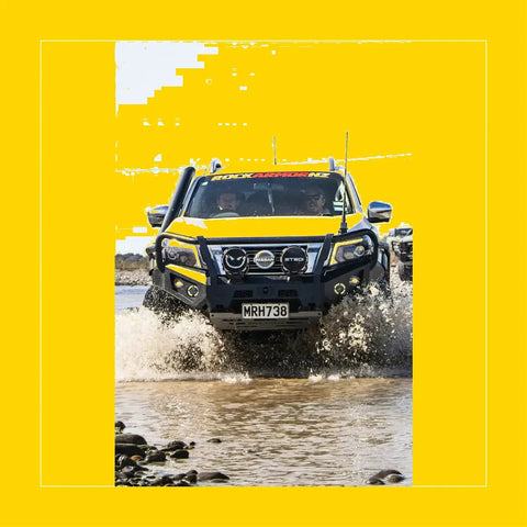Yellow nissan navara np300 with rockarmor gt hoop steel bullbar black rock armor bumper and roof rack front view