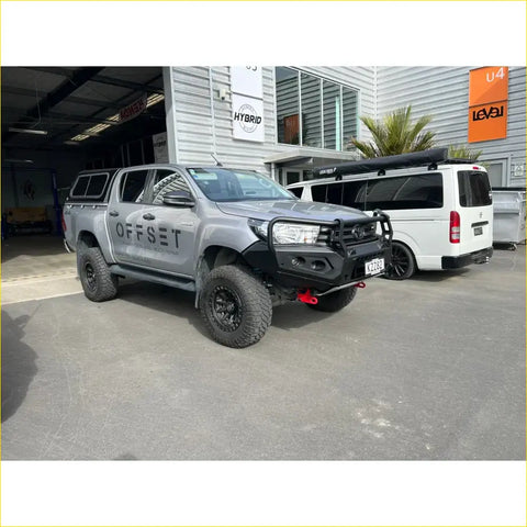 Silver toyota hilux ute with black steel rockarmor gt hoop bullbar and offset branding for offroad 4wd use