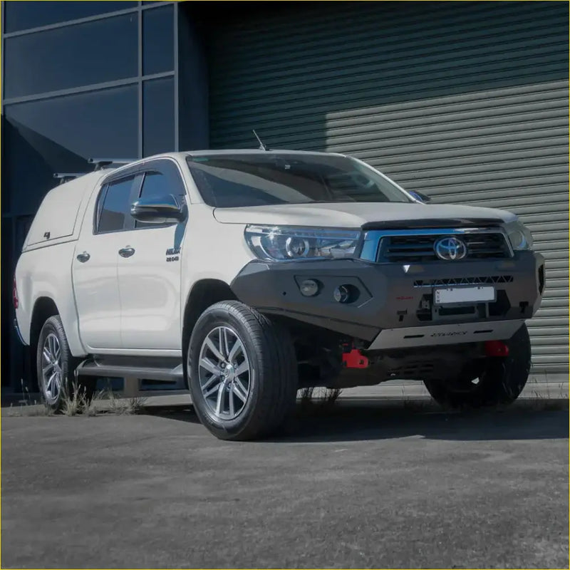 White toyota hilux 4wd ute with rockarmor gt hoopless steel bullbar and black front bumper guard for offroad use