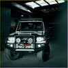 Silver toyota land cruiser with black rockarmor premium bullbar front bumper and auxiliary lights for offroad 4wd ute