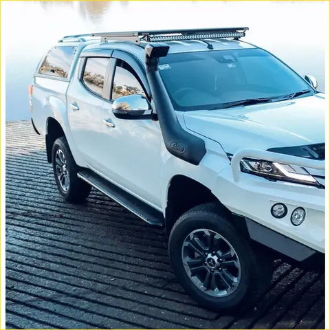 White mitsubishi triton ute with black roof rack and snorkel featuring rockarmor steel rockslider side steps for offroad 4wd