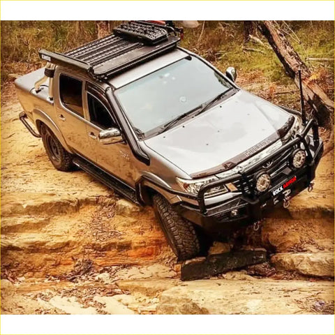 Silver toyota hilux ute with black offroad rockarmor steel rockslider side steps and rugged 4wd tires
