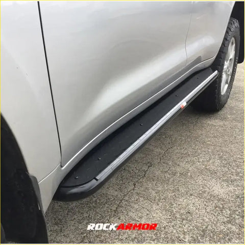 Black rockarmor steel rockslider side step with textured surface and silver trim for toyota prado 250 4wd and ute offroad use