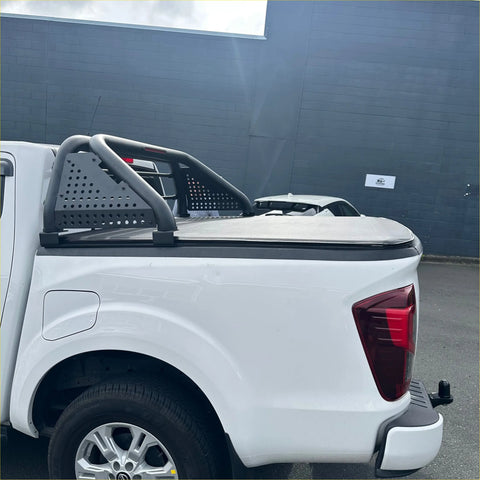 White isuzu d-max pickup truck with black perforated roll bar and matching tonneau cover seen from the back side