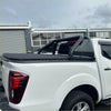 Black soft tonneau cover with integrated roll-up design and perforated metal railings on white isuzu d-max 2024 back side