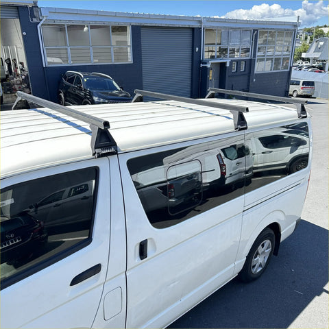 Silver aluminum heavy duty roof rack 3 piece set mounted on the back of white toyota hiace van narrow model